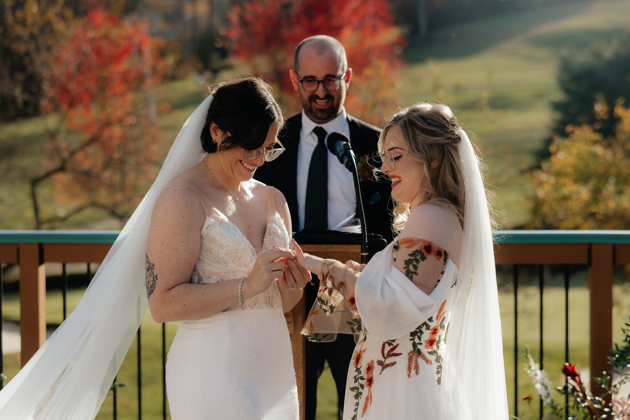 Two brides exchange rings at golden hour at Holiday Valley in Ellicottville, New York