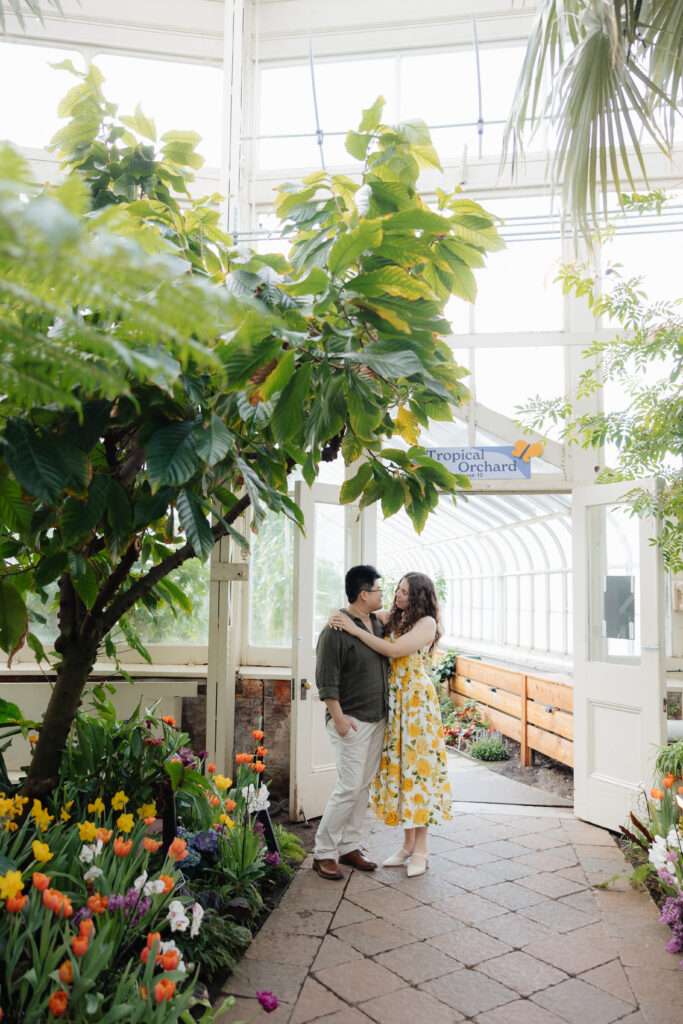 Engaged couple at the Buffalo and Erie County Botanical Gardens during a spring engagement session in Buffalo, New York