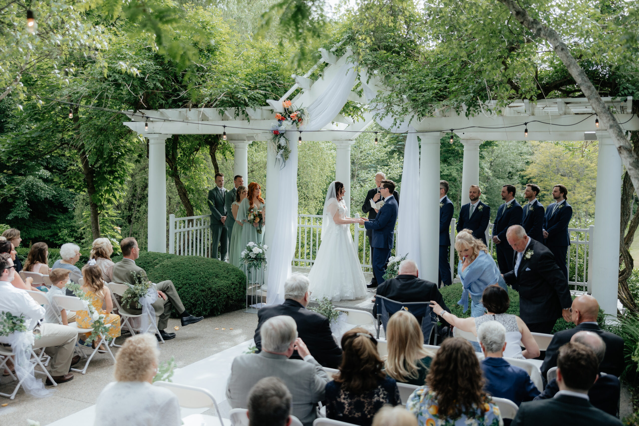 A candid side angle of a ceremony at the outdoor space of the Grand Ballroom at Kloc's Grove Venue in Buffalo, New York.