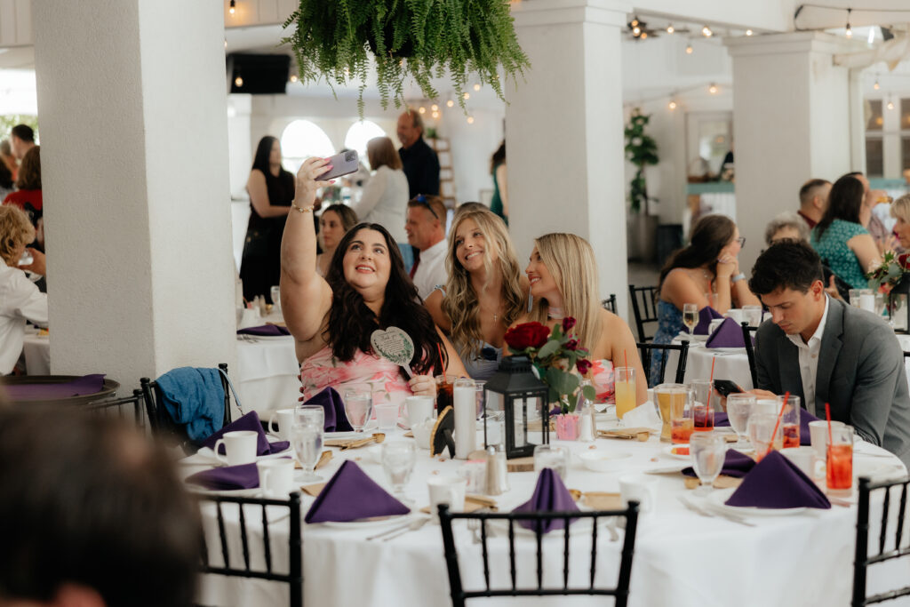 Friends pose for a selfie during a wedding reception in the Garden Pavilion at Kloc's Grove wedding venue in Buffalo, New York.