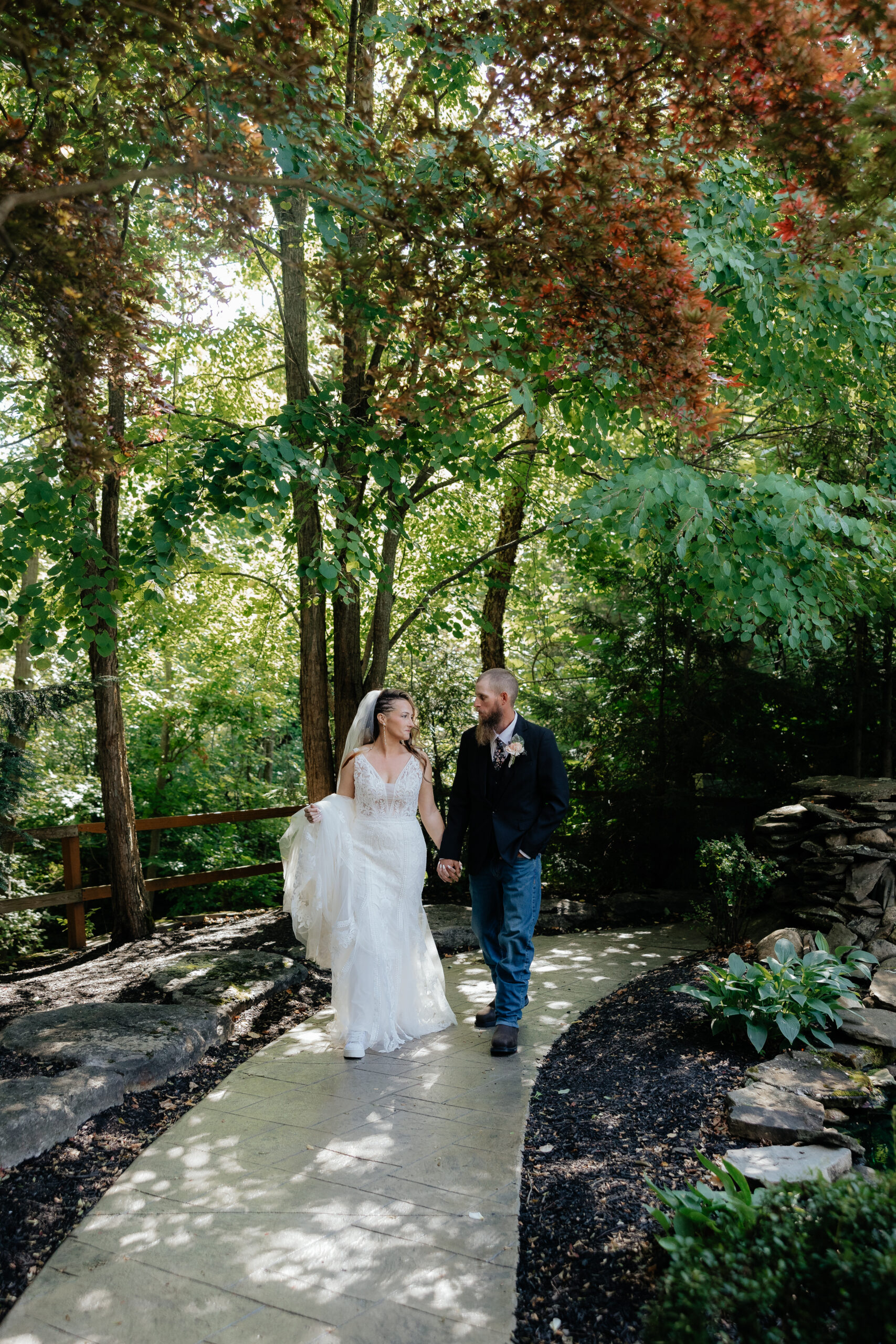 A bride and groom pose for portraits in the gardens of the Garden Pavilion at Kloc's Grove wedding venue in Buffalo, New York.